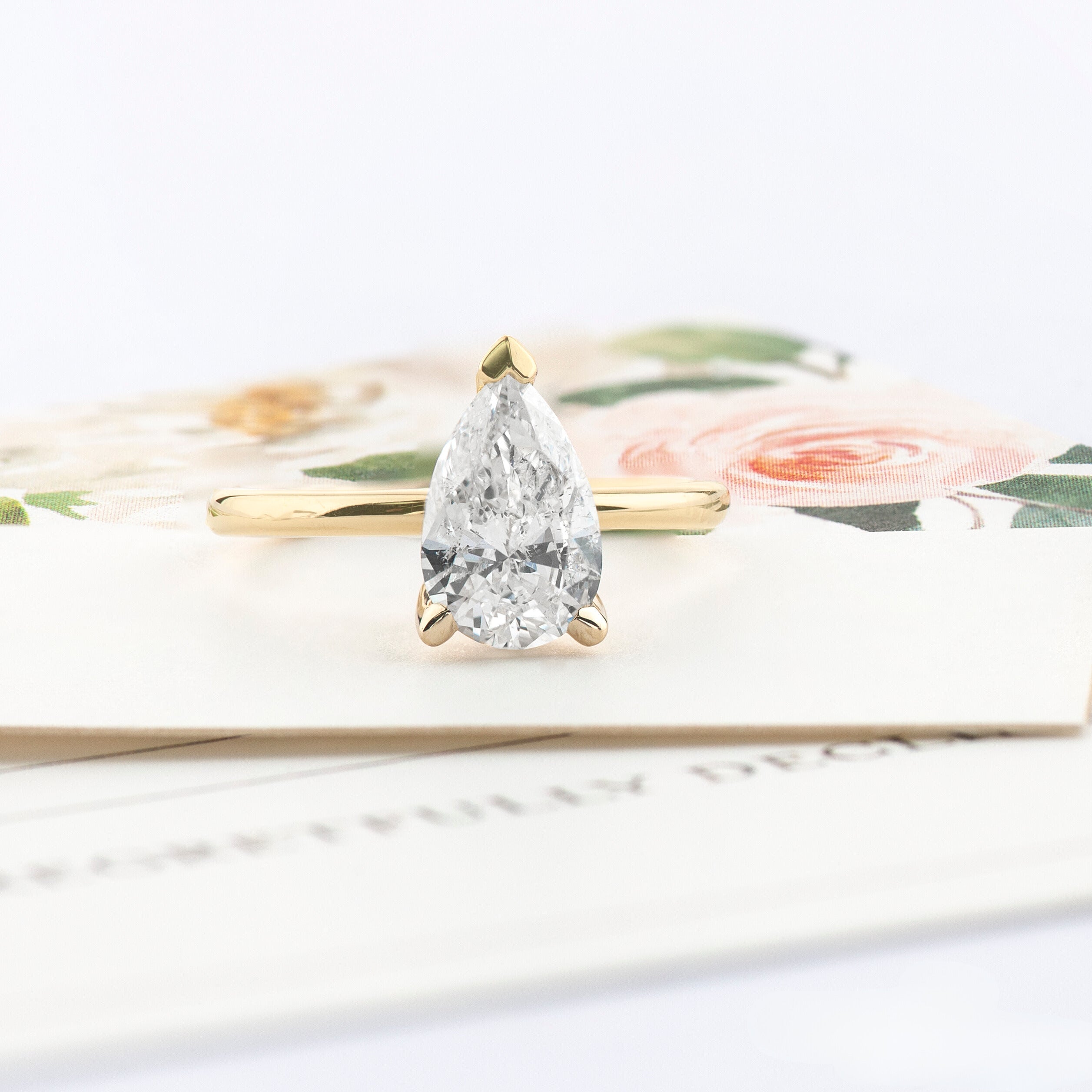 pear shaped solitaire Canadian Diamond set on a 14 karat yellow gold slim band